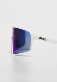 Weiße Sonnenbrille mit übergroßen rechteckigen Gläsern, die von Lila zu Blau übergehen. Sie zeichnet sich durch ein schlankes Design und ein prominentes Markenlogo an der Seite aus.