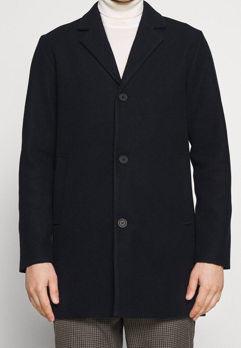 Dunkelblauer Wollmantel mit Kerbkragen, vier vorderen Knöpfen und Seitentaschen, mit geradem Schnitt und glatter Textur.