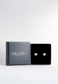 Silberne herzförmige Ohrstecker mit facettiertem Oberflächendesign, präsentiert in einer strukturierten dunkelgrauen Box mit schwarzem Innenraum.