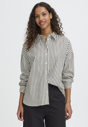 Prúžkovaná košeľa v olivovo zelenej a bielej farbe, s dizajnom na gombíky, dlhými rukávmi a voľným strihom. Mäkko tkanina s hladkým povrchom.