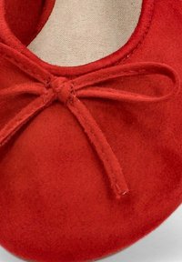 Bailarina de ante rojo con punta redonda y un lazo decorativo en la parte superior. El forro interior suave complementa la textura exterior suave.