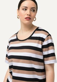 Camiseta a rayas con anchas bandas horizontales en beige, negro y blanco. Tejido suave, escote redondo y mangas cortas.
