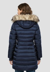 Manteau matelassé bleu marine avec une capuche en fausse fourrure. Il présente un design matelassé cousu, des manches longues et une taille cintrée, vu de dos.
