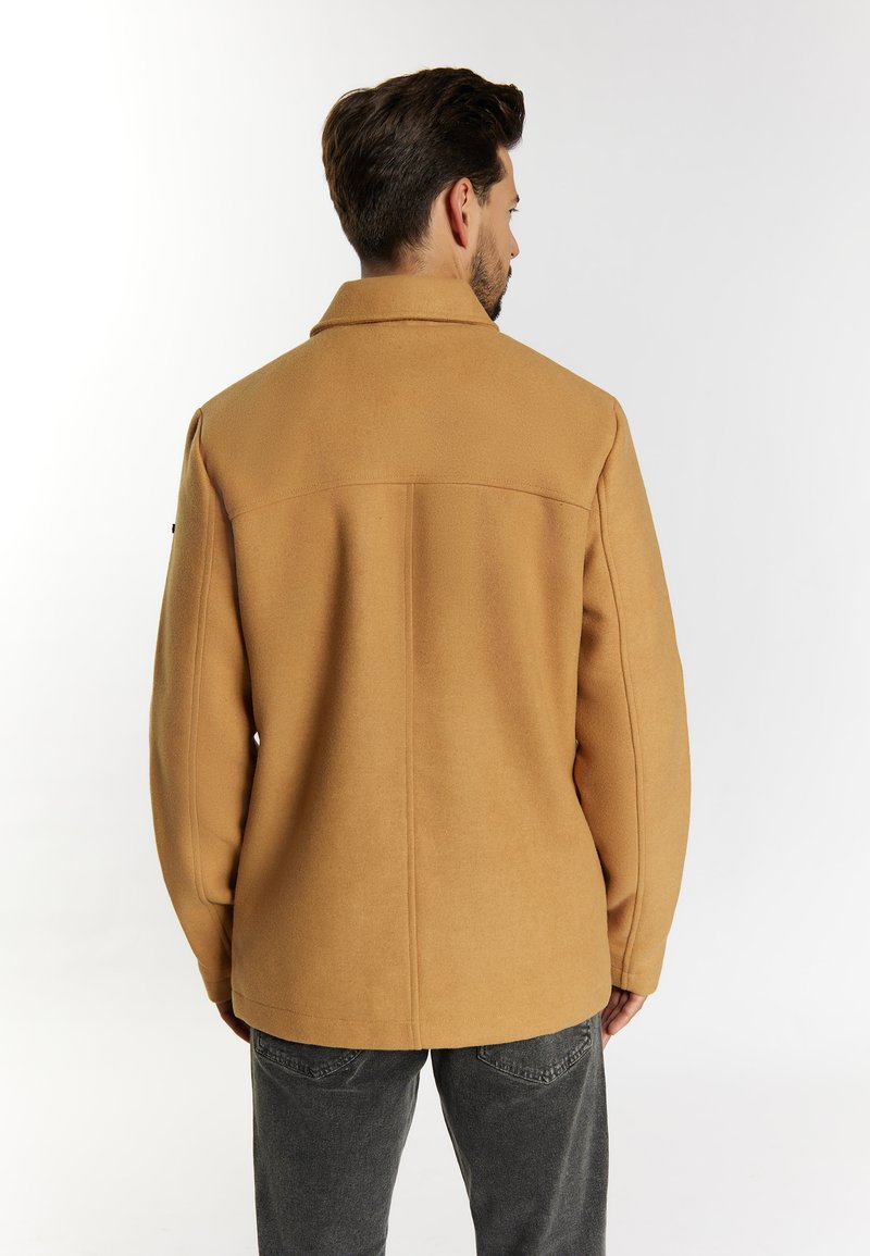 Veste en polaire couleur camel avec un col, des manches longues et une coupe droite. Présente des coutures minimales et une texture lisse.