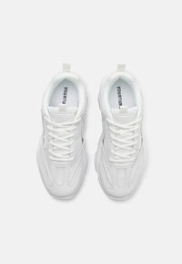 White athletic shoes feature a smooth synthetic upper with mesh accents, rounded toe, flat laces, and a rubber sole.