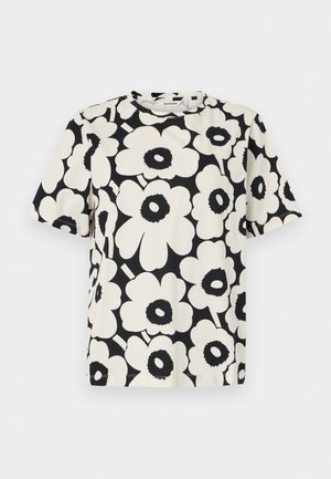 Svart-hvitt kortermet t-skjorte med stort, dristig blomstertrykk med overdimensjonerte hvite blomster med svarte sentrum.