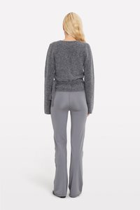 Gray knit sweater with long sleeves and back tie detail, paired with gray flared pants, view from the back. Smooth textures.