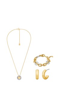 Set di gioielli oro con una collana a catena con pendente, un bracciale con anelli e dettagli, e orecchini a cerchio.