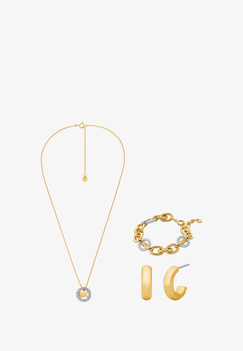 Set di gioielli oro con una collana a catena con pendente, un bracciale con anelli e dettagli, e orecchini a cerchio.