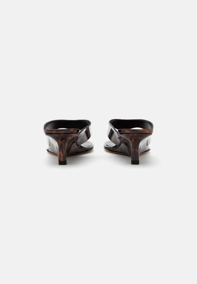 Paire de sandales mules à bout ouvert en écaille foncée avec petits talons kitten, vues de dos sur fond blanc.