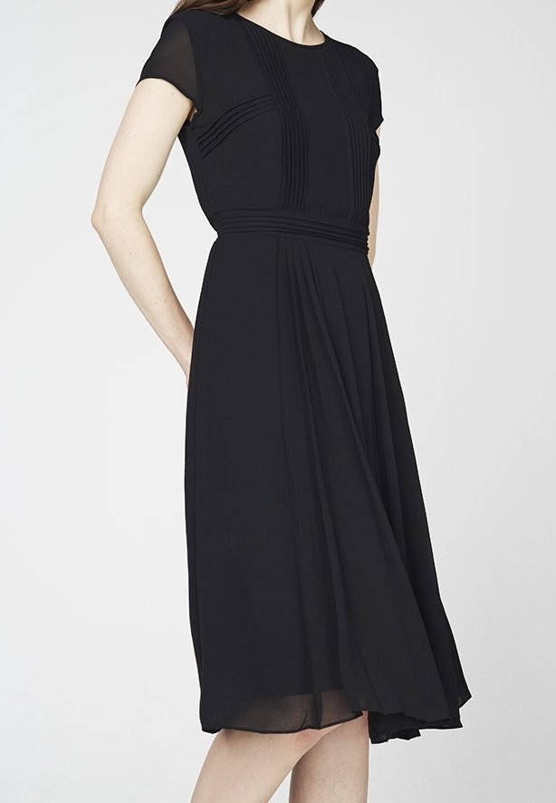 Schwarzes Kleid aus leichtem Stoff, mit kurzen Ärmeln, plissiertem Oberteil und fließendem Rock mit einer definierten Taille.
