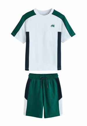 Tricou alb cu decolteu rotund, cu blocuri de culoare verde și negru, asortat cu pantaloni scurți verzi, având panouri laterale negre și albe și talie cu șnur.