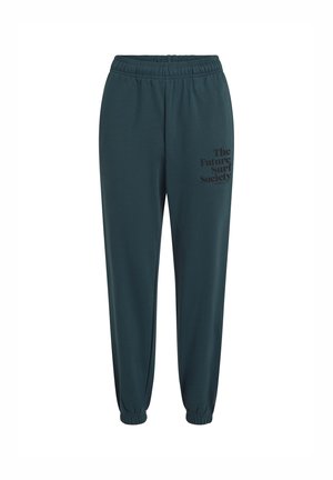Groene joggingsbroek met een elastische tailleband en boorden. Het linkerbeen heeft zwarte bedrukte tekst: "The Future Surf Society." Glad textuur.