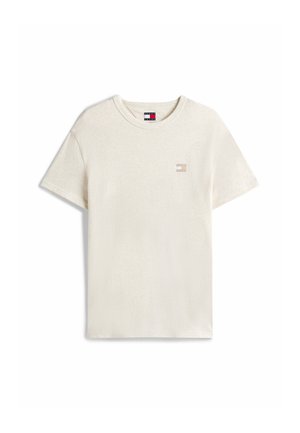 Kremowa koszulka z krótkim rękawem z bawełny z okrągłym dekoltem i małym haftowanym logo na lewej piersi. Miękka tekstura, luźny krój.