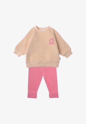 Beiger Sweatshirt mit langen Ärmeln, pinker Smiley-Blume und Schriftzug "Let Love Bloom", kombiniert mit pink- und grau gestreiften Hosen mit umgeschlagenen Ärmelbündchen.