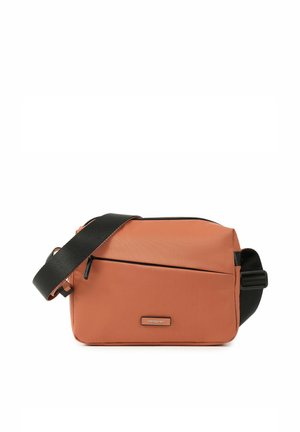 Sac bandoulière rectangulaire couleur rouille avec sangle noire réglable, poche avant zippée et petite étiquette de marque à l'avant.