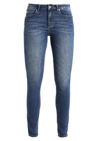 Jeans ajustados de denim azul con acabado desgastado, cintura media, bolsillos delanteros y cierre de botón de metal. Corte slim que llega hasta los tobillos.