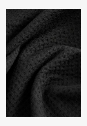 Schwarzer strukturierten Stoff mit einem subtilen gerippten Muster, das weiches, gewebtes Material mit Drapierungen und Falten zeigt.