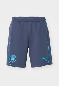 Shorts marine en tissu doux, ornés d'un liseré bleu clair sur les côtés, d'un logo de Manchester City sur la cuisse gauche et d'une taille élastique.