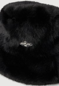 Sombrero de cubo de piel sintética negra con una etiqueta de logotipo en forma de diamante "REPLAY" en plata, textura suave y diseño de parte superior redondeada.