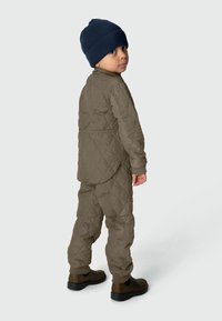 Khaki quilted jacket and pants set with ribbed navy beanie. Textured fabric with elastic cuffs and ankle openings, featuring side pockets.