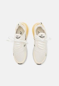 Vita sneakers med en texturerad mesh-övre, gula accenter och svart branding. Har en vadderad tunga och snörning för säker passform.