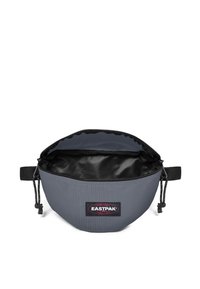 Sacchetto di tessuto grigio con interno nero, forma arrotondata, chiusura con zip e patch con logo Eastpak. Presenta un cordino regolabile sul lato.
