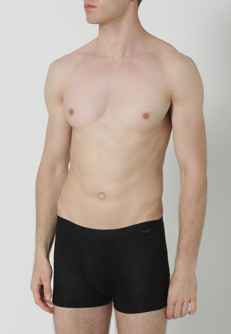 Zwarte boxer shorts van zacht stof, met een snug fit en een elastische tailleband. Het ontwerp is eenvoudig zonder zichtbare patronen of accenten.