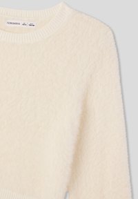 Sweter w kolorze kremowym wykonany z miękkiej, puszystej tkaniny, z okrągłym dekoltem i ściągaczami przy mankietach. Charakteryzuje się luźnym krojem i brakiem widocznych wzorów.