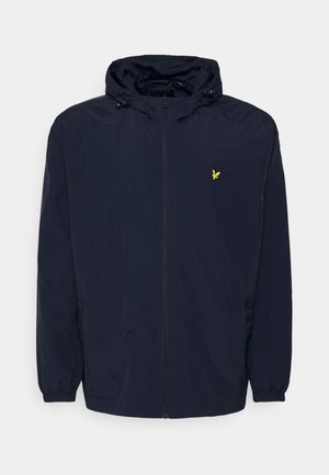Tumed sinine kapuutsiga jakk, millel on ees lukku, elastsed mansetid, reguleeritavad kapuutsi nöörid ja rinnal väike kollane tikitud linnu logo.