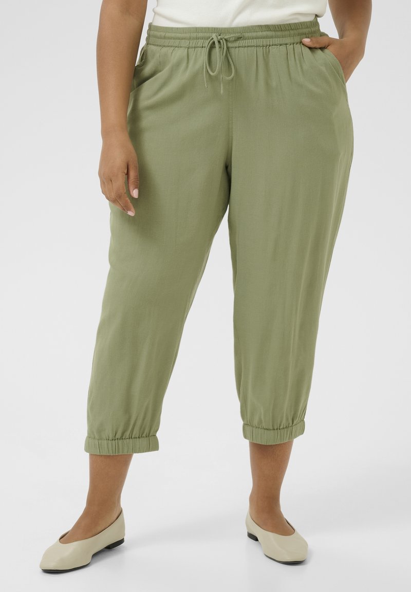 Light green, elastic waist pants with a drawstring, side pockets, and gathered cuffs. Pairing with beige flat shoes.