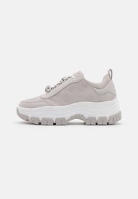 Sneaker grigio chiaro con tomaia testurizzata caratterizzata da un motivo sottile, suola bianca spessa e trazione in gomma grigia in un design chunky.
