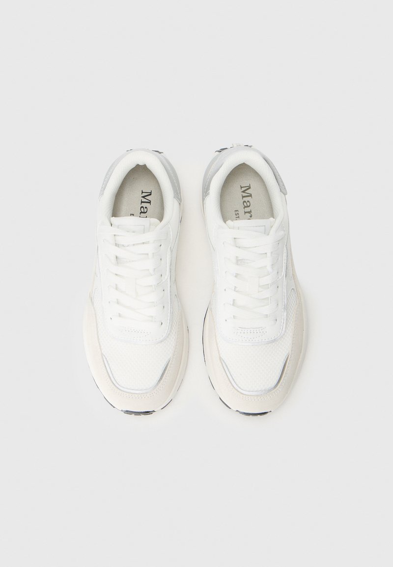 Witte sneakers van mesh en suede materialen. Ronde neus, gewatteerde kraag, platte veters, en een lichtgrijze accent op de hiel. Zwarte zool.