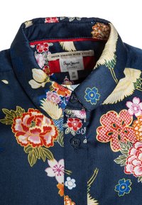 Marineblå skjorte med blomstermønster i en blød tekstur, med klassisk krave, knaplukning og livlige blomster i rød, gul og blå.