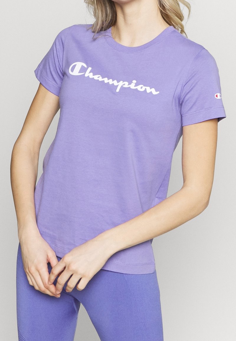 Lila bomull t-shirt med en vit "Champion" logga över bröstet, kortärmad och med en klassisk rund hals.