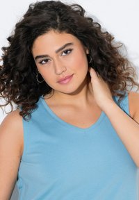 Top senza maniche di colore azzurro chiaro con scollatura a V, realizzato in un tessuto liscio. Presenta una vestibilità rilassata e una texture delicata.