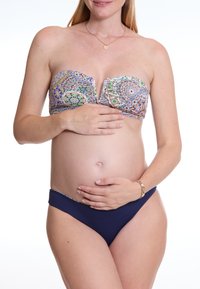 Badeanzug-Set mit einem schulterfreien, gemusterten Oberteil in Blau, Grün und Lila sowie einem einfarbigen navyblauen Unterteil, aus glattem Stoff und minimalistischem Design.
