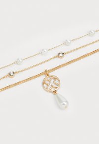 Gold-tone layered necklace featuring pearl and rhinestone accents, an engraved charm with a floral design, and a teardrop pearl pendant.