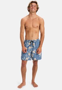 Pánske plavky v modrej farbe s kvetinovým vzorom, ktorý zahŕňa biele a červené kvety. Sťahovacia páska v páse a ľahký materiál.