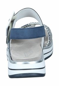 Sandalo blu navy con design in tessuto intrecciato, cinturino alla caviglia regolabile, soletta imbottita e suola in gomma a strisce bianche e nere.