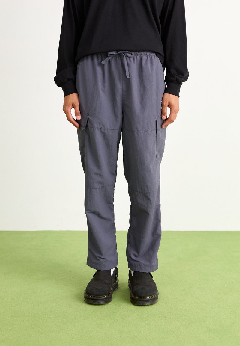 Graue Cargo-Hosen aus leichtem Material, mit einem elastischen Bund, zwei Seitentaschen und einer lockeren Passform.