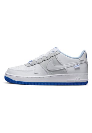 Baskets blanches Nike Air Force 1 avec doublure intérieure bleu clair, semelle extérieure bleue et logo Nike swoosh sur le côté sur fond blanc.