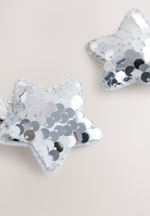 Silver star-shaped hair clips covered in shiny sequins, with a textured edge and a silver elastic band for securing in hair.