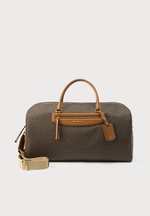 Borsa da viaggio Michael Kors marrone con manici in pelle beige, tasca frontale con cerniera e tracolla regolabile beige su sfondo bianco.