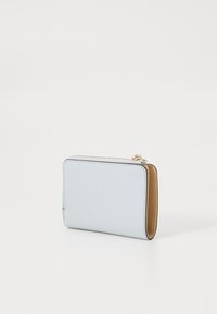 Portefeuille texturé bleu clair avec un intérieur lisse beige. Forme rectangulaire, fermeture éclair, et accents en matériel doré. Design compact.