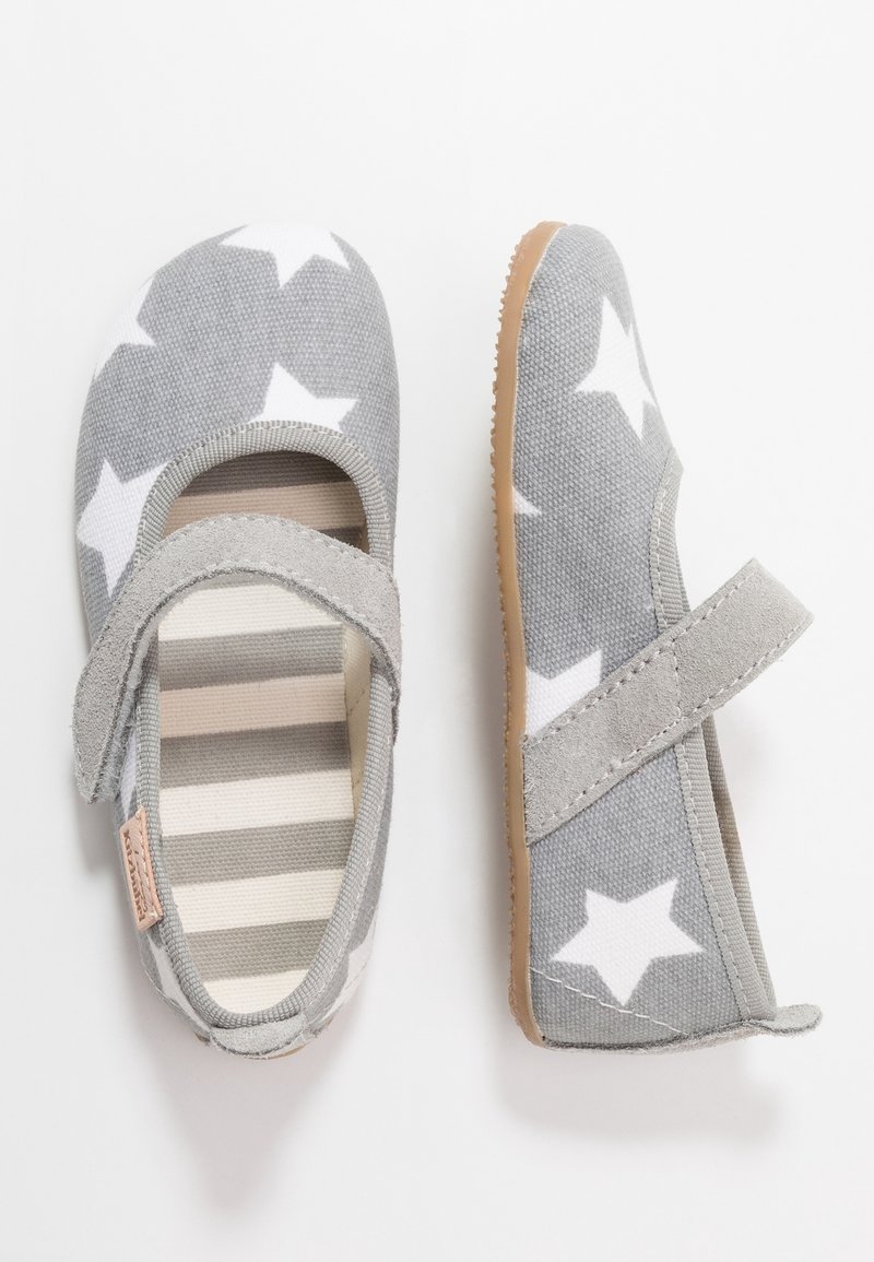 Harmaat kankaat vauvan kengät valkoisilla tähdillä, beige raidalliset pohjat ja tarranauhat, esitetty ylhäältä ja sivulta.