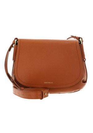 Sac bandoulière en cuir marron avec sangle ajustable et fermeture à rabat, nom de la marque "Coccinelle" en petites lettres dorées sur le devant.