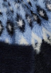 Kék és fekete árnyalatú műszőrme anyag, csillag mintával és változatos textúrákkal, amely kiemeli a puha, bolyhos felületet.