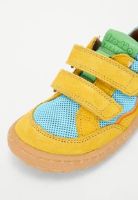 Baskets jaunes et bleues en suède et en maille, dotées de deux bandes auto-agrippantes, d'une semelle en caoutchouc et de détails en accent orange.