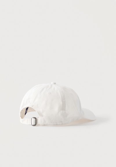 Casquette de baseball blanche ajustable vue de dos, avec boucle métallique et sangle en tissu sur un fond clair uni.